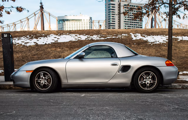 Silberner Porsche Boxster 986 mit Hardtop am Straßenrand, Seitenansicht