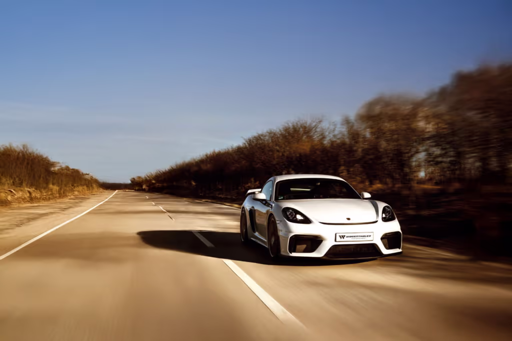 Porsche weiß fährt schnell auf Straße im Herbst