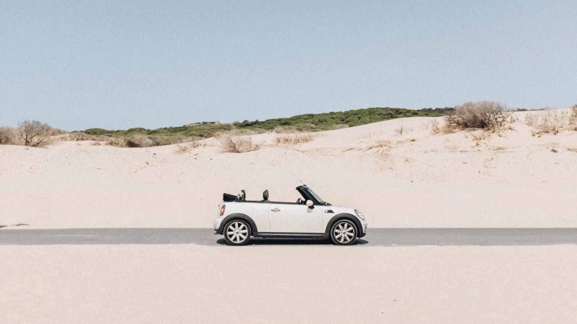 Kleiner weißer MINI auf Straße am Strand – MINI Spezialwerkstatt München